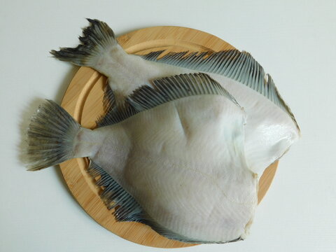 two fresh flounders, large and small, before cooking.