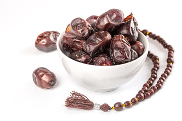 Muslim background for the holy month of Ramadan with dried dates in white bowl, and a rosary on white