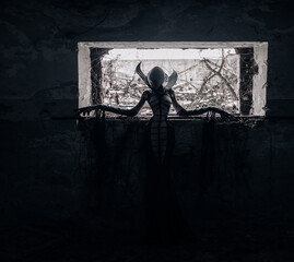 Woman portrays alien creature inside abandoned house.