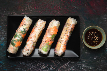 Asian spring rolls set with shrimps, eggs, vegetables and herbs, served with sweet sauce.