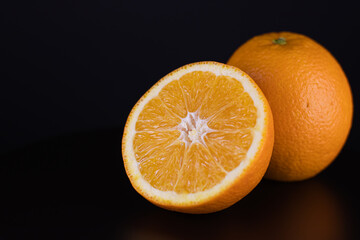 Oranges on a black background isolated. Close-up vitamins.
