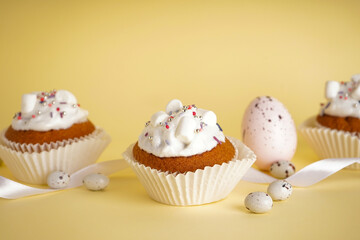 Delicious Easter cupcakes on yellow background, close up.