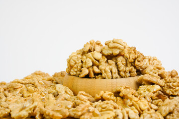  Peeled walnuts in wooden bowl.  Nuts on white background. Copy space. Studio shot.