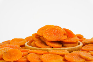 Dried apricots on white background. Naturally dried apricot on white.  Sun dried fruits in wooden bowl. Product for sale. Copy space. 