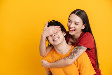 Young white woman laughing while covering her boyfriend's eyes