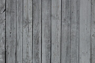 The texture of gray from old wooden planks arranged in a vertical order. Background for further design. Ancient building material. Rough relief texture of natural wood. Combustible insulating surface