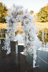 White pillars and arch decorated with pink and white peonies