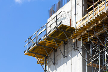 Scaffolding on the concrete walls of a newly constructed public utility building. Grodzisk Mazowiecki, Poland. Photo taken on a sunny day.