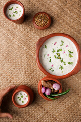 Fototapeta na wymiar Spiced buttermilk , chaas , chaach , moru , sambharam , curd, lassi , yogurt, cool refreshing drink for hot summer in a clay pot, Kerala, India. Flavored Indian buttermilk.