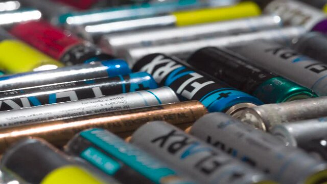 Ornament from Used Batteries. HD Loop. A large number of multi-colored batteries arranged in a perpendicular pattern move in front of the camera