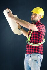 Construction Worker  on black background views the building plan. Construction worker with yellow...