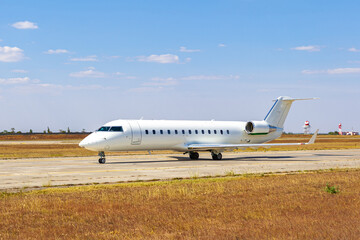 Big passenger airplane drives along the runway in airport
