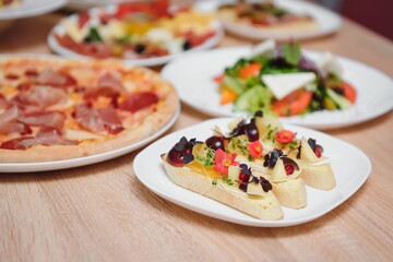Different salads on wooden table, top view. Vegetable salad, Salad with smoked duck, Grilled chicken Caesar salad.