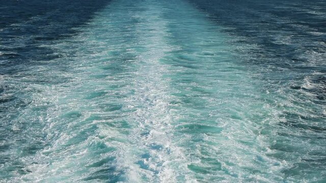 Wave of large cruise ship on the sea. Speed boat on blue ocean splashing water and breaking the waves. Luxury boat cruising. Cruiser power boat on water. Spray and foam in a ship wake
