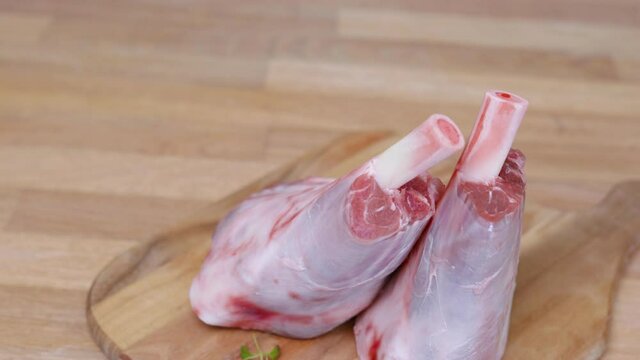 Two Lamb Shanks on Wooden Cutting Board. - Top Down Shot