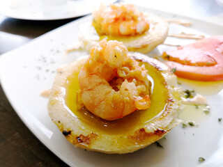 Delicious Spanish tapas made with black bread and prawns on top