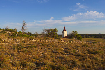 Fototapeta premium Small white church on deserted rocky land at sunset near Vrsi, Dalmatia, Croatia