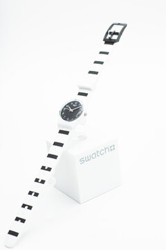New York, NY, USA 07.10.2020 - Swatch swiss made quartz watch isolated on white background. white plastic case. Black stripes design strap. Swatch Group watch production