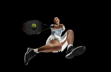 Female professional tennis player in action, motion isolated on black background, look from the...