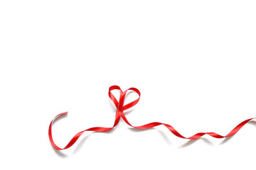 narrow red satin ribbon folded into a heart on a white background