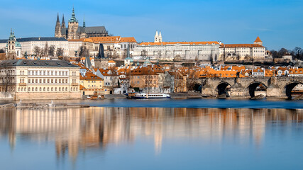 Charles Bridge, St. Vitus Cathedral and other historical buildings in Prague reflected in the river. This image is toned.