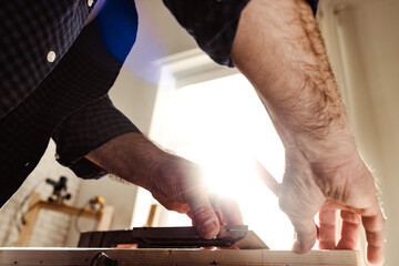 Male carpenter working with a wooden bar in a workshop