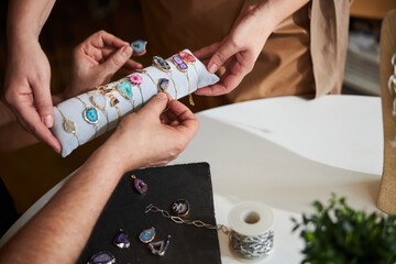 Obraz premium Artisan picking the right gemstone bracelets for his earrings