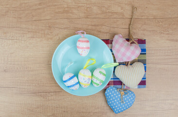 Colorful Easter eggs on ceramic round plate with colorful napkin. View from above, top with copy space.