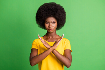 Photo of brunette wavy haired dark skin woman hold hands crossed angry mood isolated on green color background