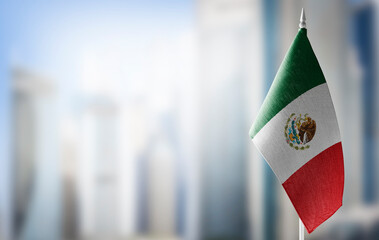 A small flag of Mexico on the background of a blurred background