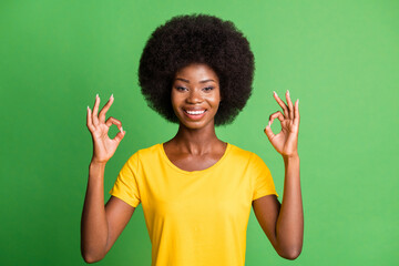 Photo portrait of happy girl showing ok sign gesture fingers smiling isolated on vibrant green color background