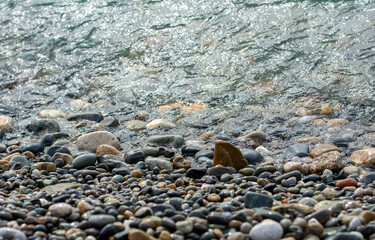 pebbles on the seaside with a triangular stone in the form of a sailboat