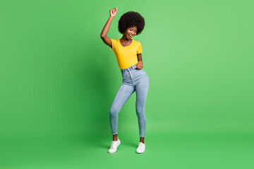 Fototapeta na wymiar Full size photo of young beautiful smiling cheerful afro woman dancing enjoying weekend isolated on green color background