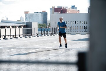 Obraz premium Fitness, workout, sport, lifestyle concept. Middle-aged man running in the city