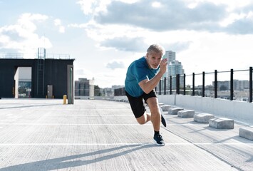 Fitness, workout, sport, lifestyle concept. Middle-aged man running in the city