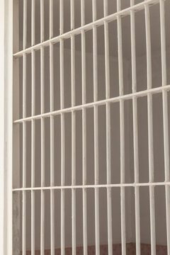 White steel bars inside a prison cell.