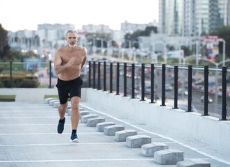 Fototapeta na wymiar Fitness, workout, sport, lifestyle concept. Middle-aged man running in the city
