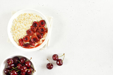 Oatmeal porridge with cherry slices in bowl