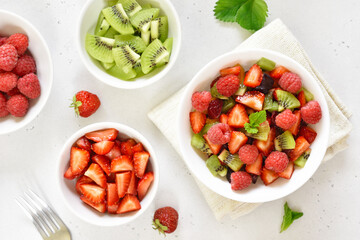 Healthy breakfast with fruit salad from strawberry, kiwi and raspberry