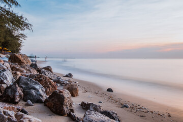Fototapeta na wymiar long exposure Sea rocks Magnificent sunrise view at sunrise Romantic atmosphere in peaceful morning at sea. Pink horizon with first hot sun rays. 