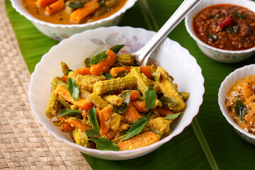 Aviyal curry for Onam Sadhya mixed vegetable curry with grated coconut side dish of rice Kerala on banana leaf background Kerala, Tamil Nadu in South India. Top view Indian veg festival food.