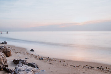 long exposure Sea rocks Magnificent sunrise view at sunrise Romantic atmosphere in peaceful morning at sea. Pink horizon with first hot sun rays.
