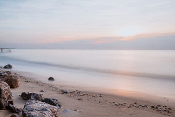 long exposure Sea rocks Magnificent sunrise view at sunrise Romantic atmosphere in peaceful morning at sea. Pink horizon with first hot sun rays.
