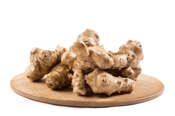 Jerusalem artichokes on wooden plate. Heap of Jerusalem artichokes isoalted on white.