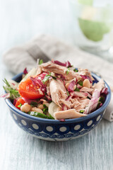 Tuna salad with tomatoes, cannelloni bean and endive. Bright wooden background. Close up.	
