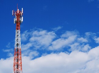 Telephone tower with white clouds in the background.