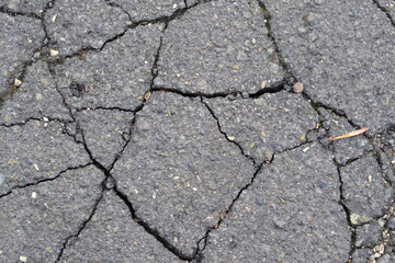 Wet dark asphalt texture with cracks