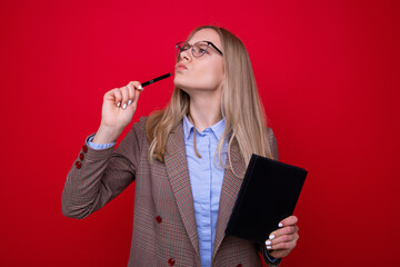 Portrait of a young woman in business clothes with a diary and a pen