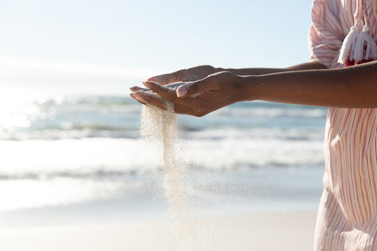 Mixed Race Woman On Beach Holiday Spilling Sand