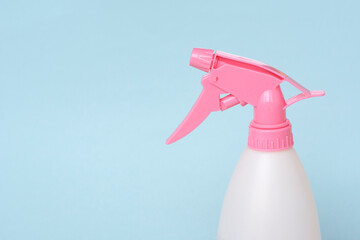 Colorful plastic spray bottle on a blue background